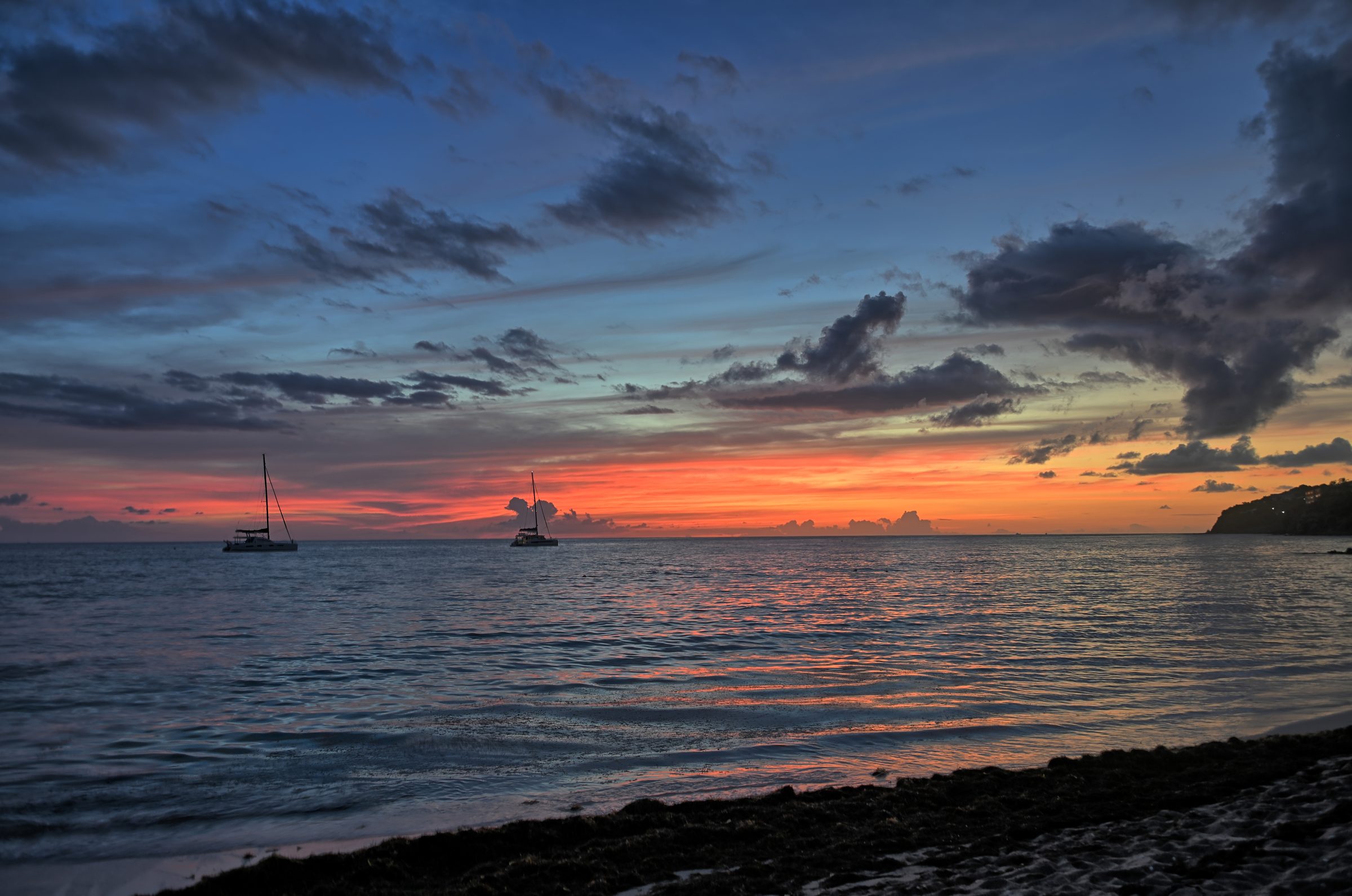 Off the Clock — The day burns out over two boats at anchor.